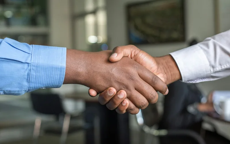 Handschlag zweier Vertragspartner in einem Besprechungsraum