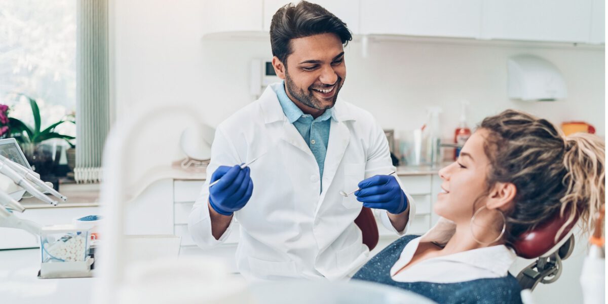 Zahnarzt behandelt eine Patientin auf dem Patientenstuhl. 